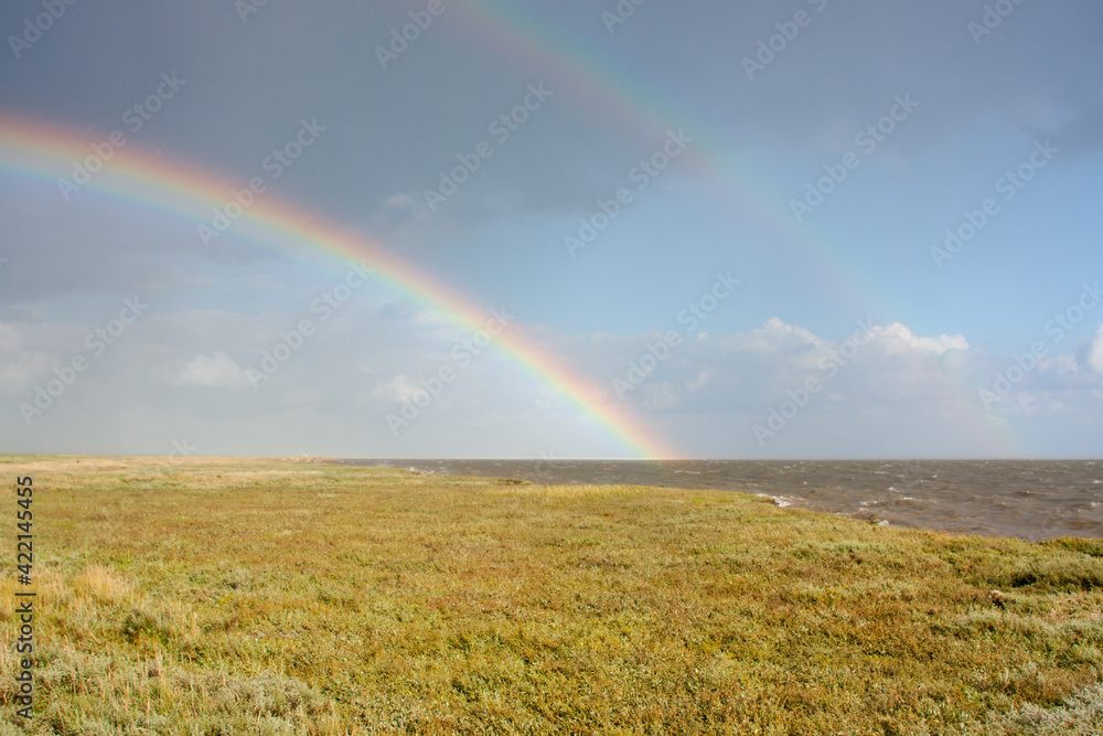 Double rainbow above salt marsh and sea