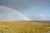 Double rainbow above salt marsh and sea