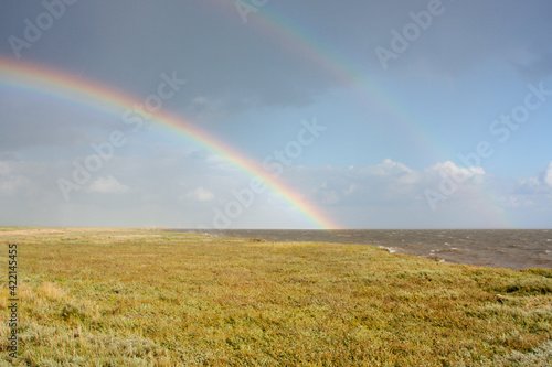 Double rainbow above salt marsh and sea