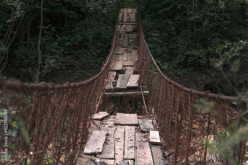 Destroyed suspension bridge over a mountain river (concept: dangerous path)