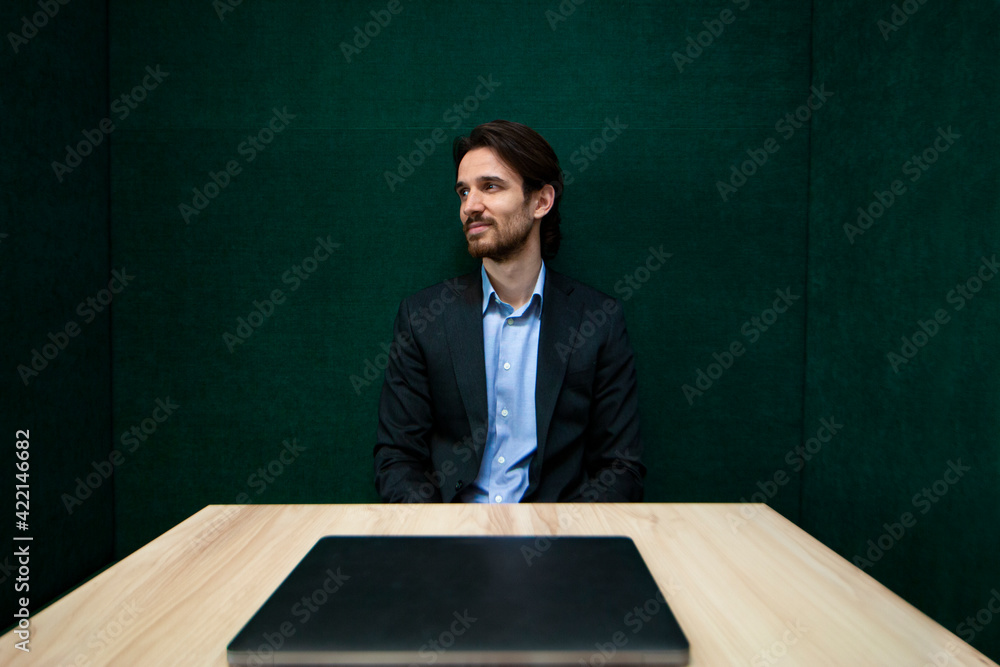Portrait of young businessman with green wall in the background Portrait of young businessman with green wall in the background