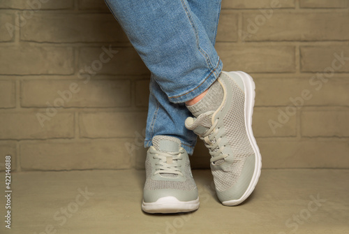 Women's sports comfortable shoes on concrete on the background of a brick wall