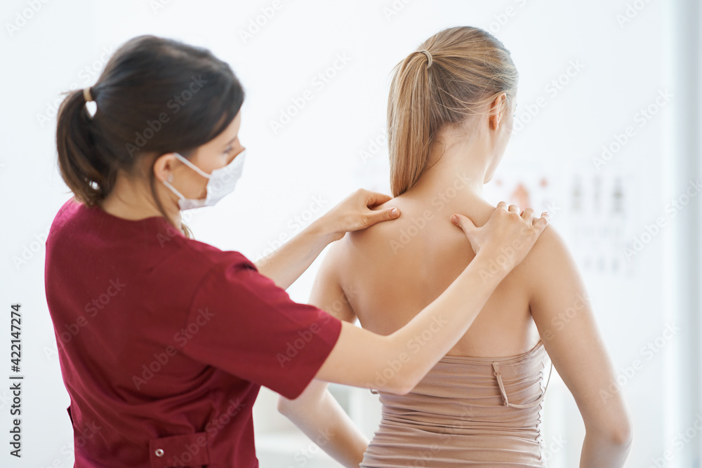 Physiotherapist in mask helping female patient Physiotherapist in mask helping female patient