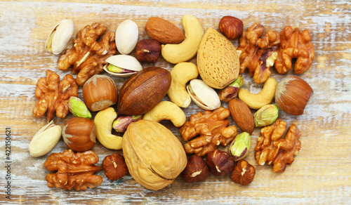 Obraz na płótnie Selection of walnuts, pistachios, hazelnuts, cashew nuts and almonds on rustic wooden surface
w salonie