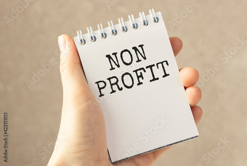 Businessman Holding Small White Signage Showing Non Profit Texts.