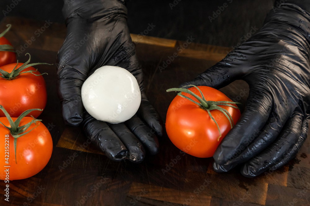Mozzarella cheese and fresh tomato in the hands