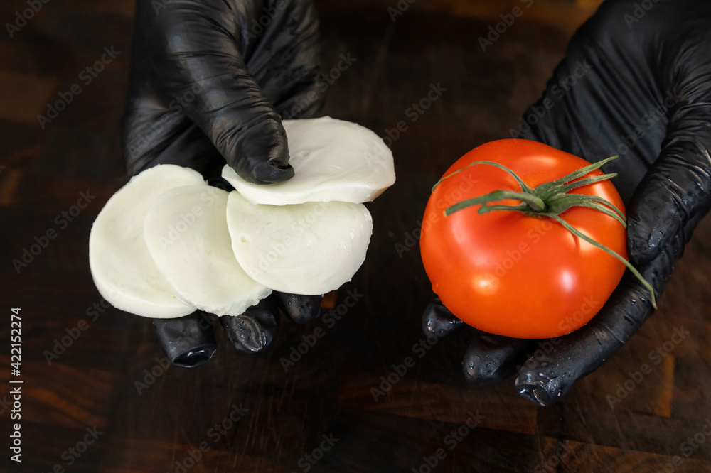 Mozzarella cheese and fresh tomato in the hands