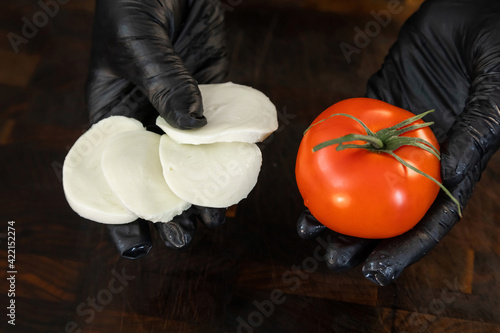 Obraz na płótnie Mozzarella cheese and fresh tomato in the hands w salonie