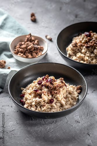 Fresh oatmeal with granola, syrup and nuts