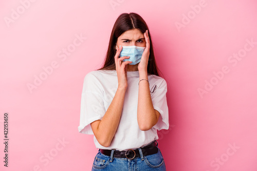 Young caucasian woman wearing a mask for virus isolated on pink background whining and crying disconsolately.