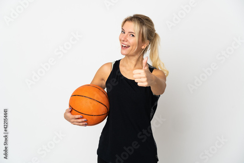 Young Russian woman playing basketball isolated on white background with thumbs up because something good has happened