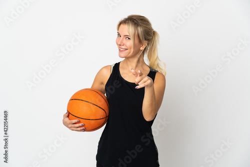 Young Russian woman playing basketball isolated on white background pointing front with happy expression