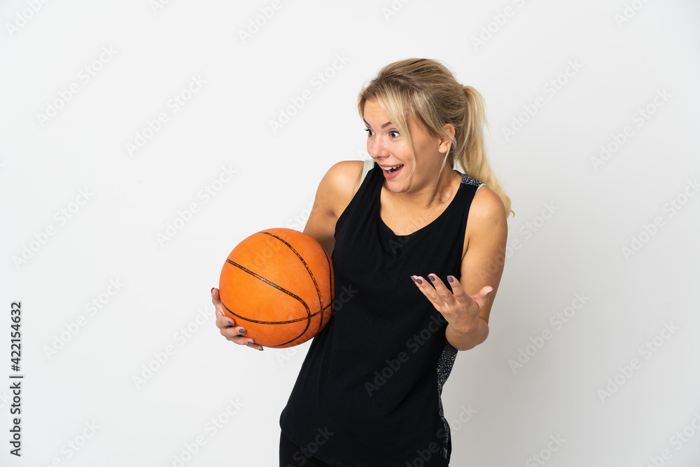 Young Russian woman playing basketball isolated on white background with surprise expression while looking side