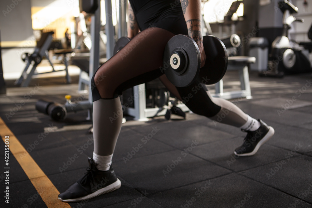 Cropped shot of a woman doing lunges with weights Cropped shot of a woman doing lunges with weights