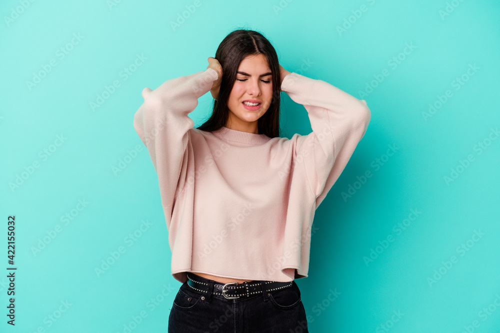 Young caucasian woman isolated on blue background covering ears with hands. Young caucasian woman isolated on blue background covering ears with hands.