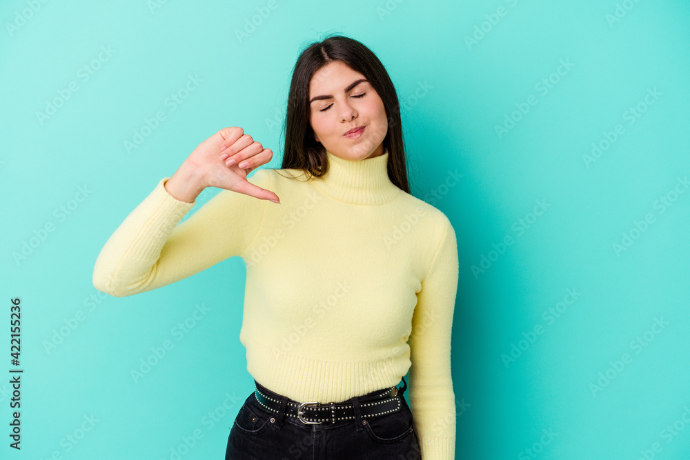 Young caucasian woman isolated on blue background showing a dislike gesture, thumbs down. Disagreement concept. Young caucasian woman isolated on blue background showing a dislike gesture, thumbs down. Disagreement concept.