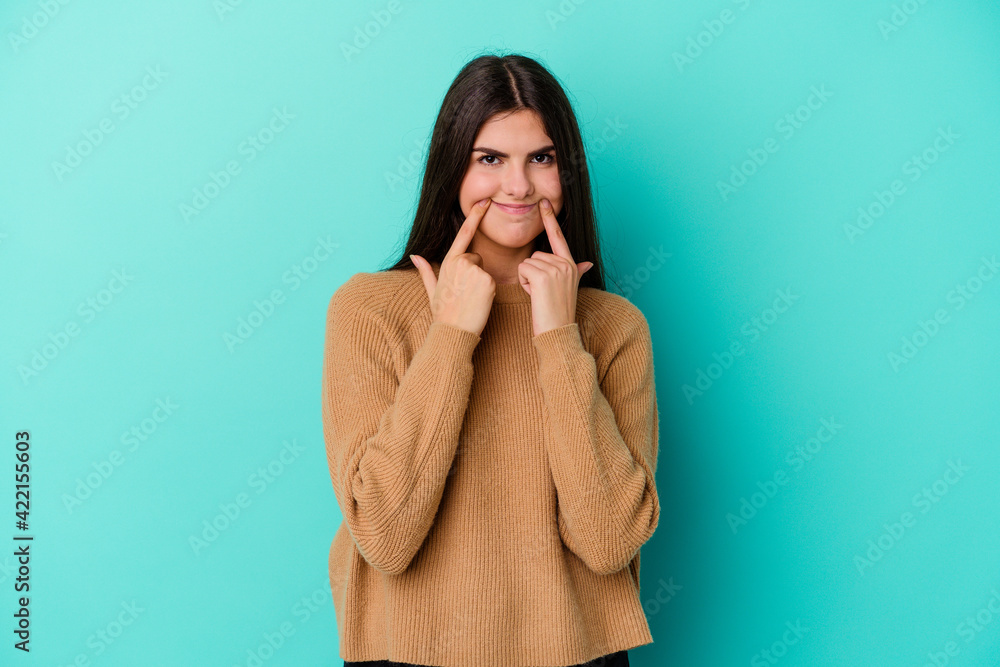 Young caucasian woman isolated on blue background doubting between two options. Young caucasian woman isolated on blue background doubting between two options.