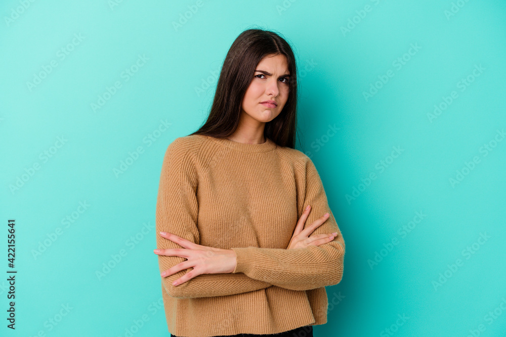 Young caucasian woman isolated on blue background suspicious, uncertain, examining you. Young caucasian woman isolated on blue background suspicious, uncertain, examining you.