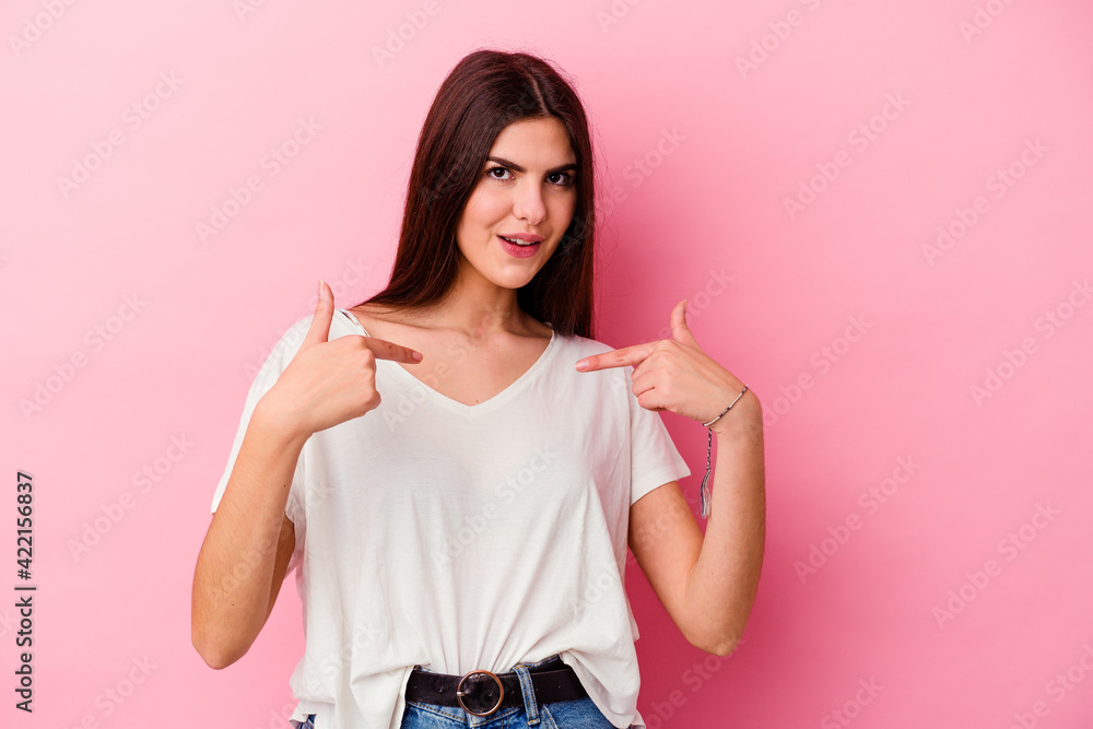 Young caucasian woman isolated on pink background surprised pointing with finger, smiling broadly. Young caucasian woman isolated on pink background surprised pointing with finger, smiling broadly.