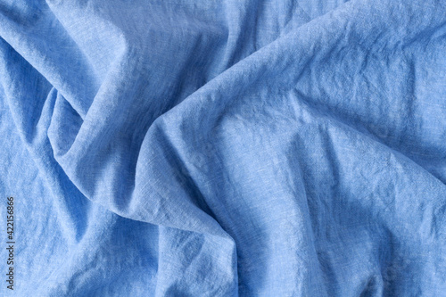 Creased blue color natural linen fabric as background with copy space 