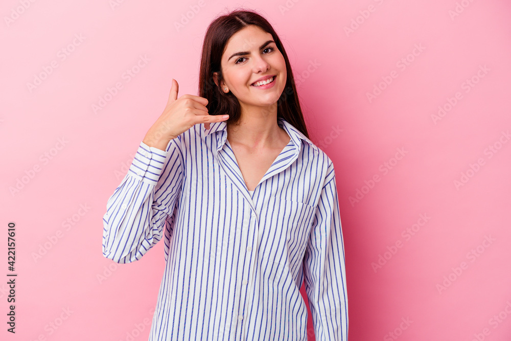 Young caucasian woman isolated on pink background showing a mobile phone call gesture with fingers. Young caucasian woman isolated on pink background showing a mobile phone call gesture with fingers.