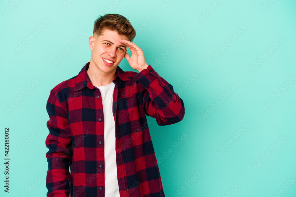 Young caucasian man isolated on blue background shouts loud, keeps eyes opened and hands tense. Young caucasian man isolated on blue background shouts loud, keeps eyes opened and hands tense.
