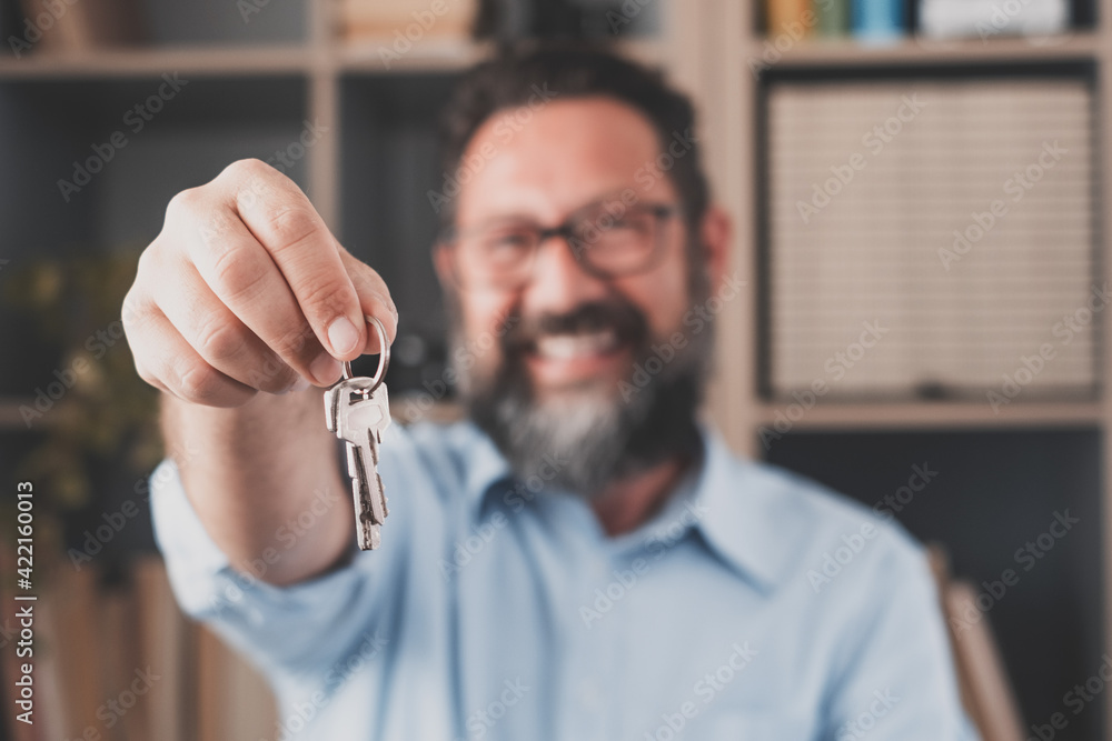 Focus on bunch of keys from house flat apartment in hand of smiling female. Blurred portrait of confident woman professional realtor offering new dwelling real estate unit to potential buyer. Close up Focus on bunch of keys from house flat apartment in hand of smiling female. Blurred portrait of confident woman professional realtor offering new dwelling real estate unit to potential buyer. Close up