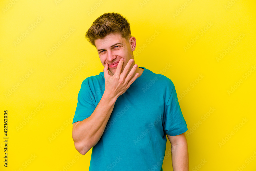 Young caucasian man isolated on yellow background doubting between two options. Young caucasian man isolated on yellow background doubting between two options.
