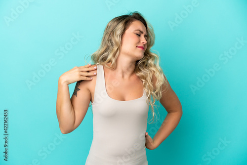 Young Brazilian woman isolated on blue background suffering from pain in shoulder for having made an effort © luismolinero