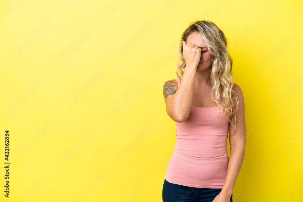 Young Brazilian woman isolated on yellow background with headache Young Brazilian woman isolated on yellow background with headache