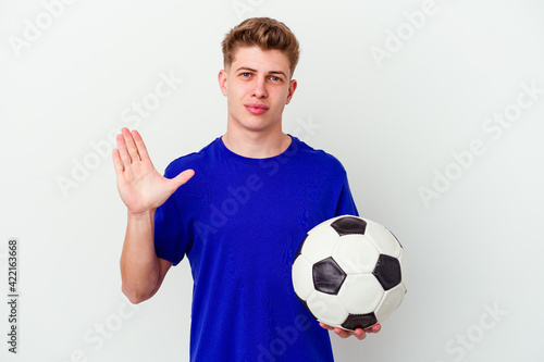 Young caucasian man playing soccer isolated on background smiling cheerful showing number five with fingers.