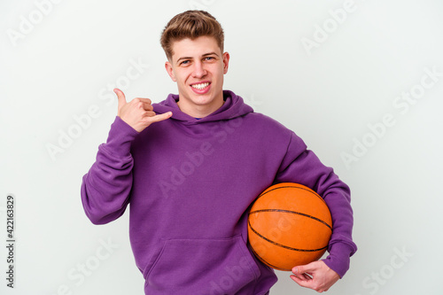 Young caucasian man playing basketball isolated background showing a mobile phone call gesture with fingers.
