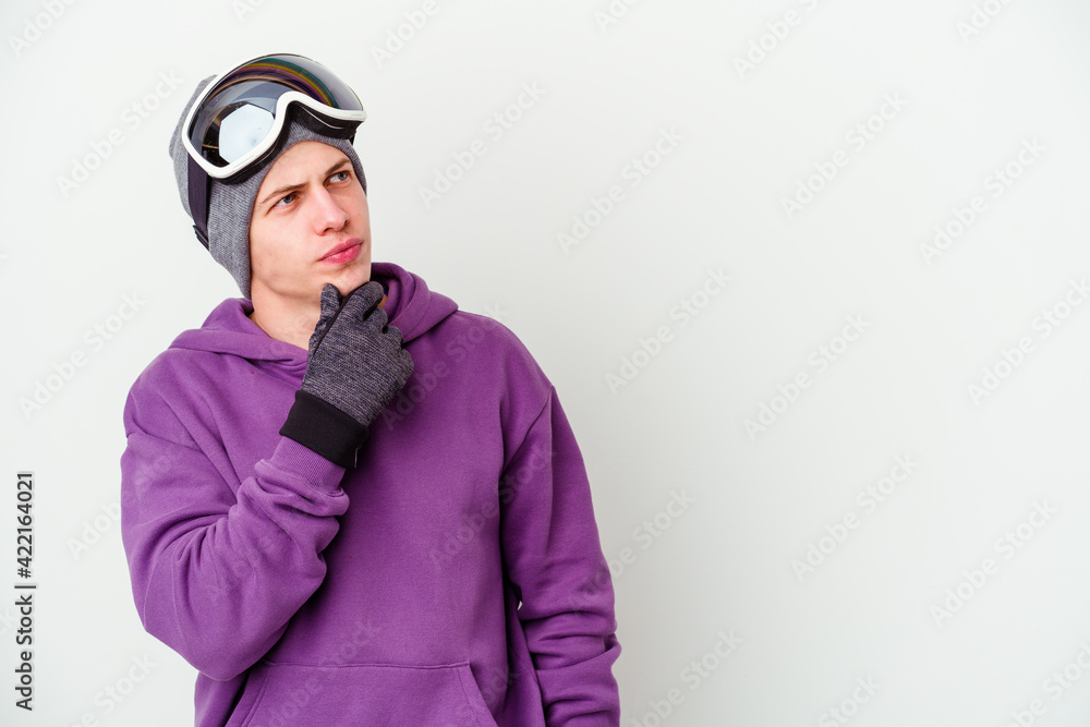 Young man holding a snowboard board isolated on white background looking sideways with doubtful and skeptical expression. Young man holding a snowboard board isolated on white background looking sideways with doubtful and skeptical expression.