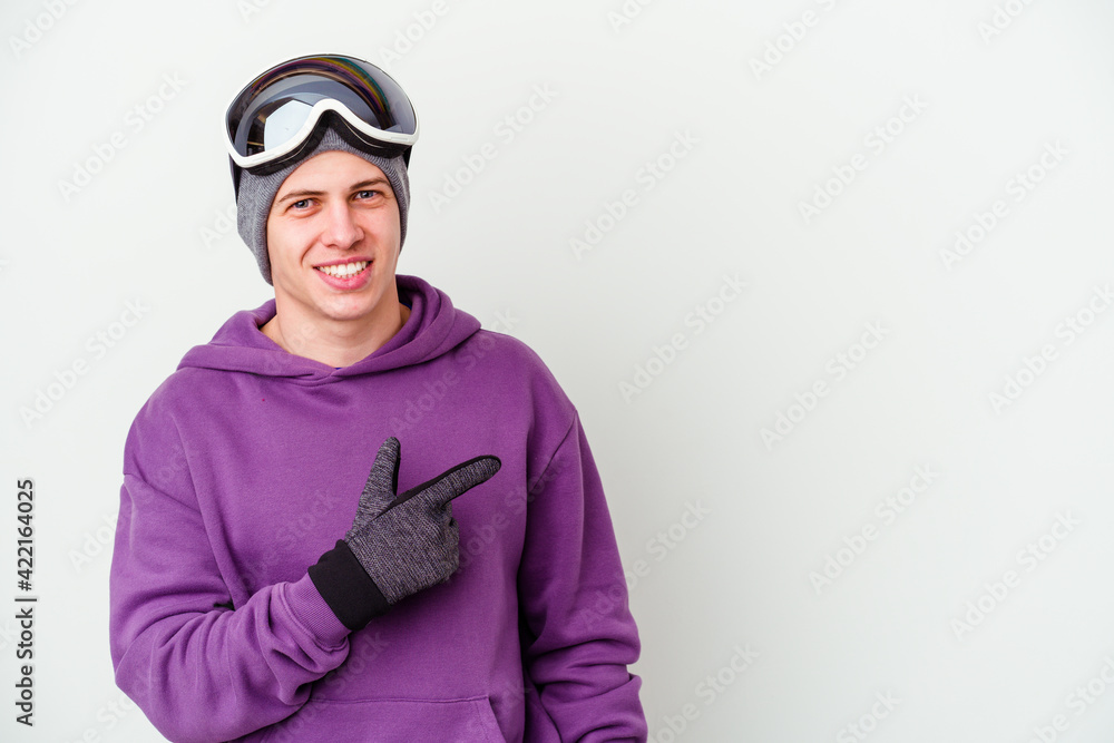 Young man holding a snowboard board isolated on white background smiling and pointing aside, showing something at blank space. Young man holding a snowboard board isolated on white background smiling and pointing aside, showing something at blank space.