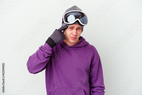 Young man holding a snowboard board isolated on white background showing a disappointment gesture with forefinger.