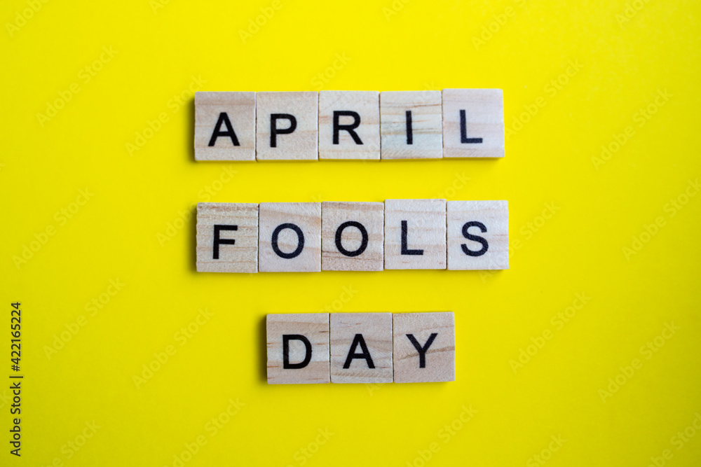 top view of alphabet blocks with letters on bright yellow background. April fools day - lettering top view of alphabet blocks with letters on bright yellow background. April fools day - lettering