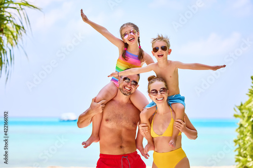 Happy family in colorful swimsuits on beach © JenkoAtaman