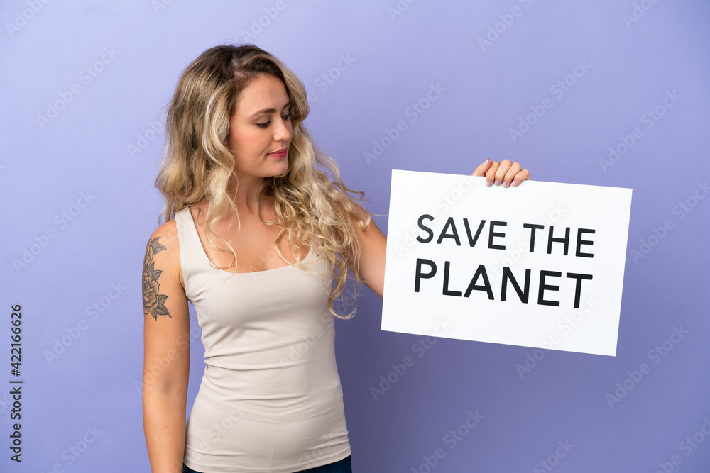 Young Brazilian woman isolated on purple background holding a placard with text Save the Planet Young Brazilian woman isolated on purple background holding a placard with text Save the Planet