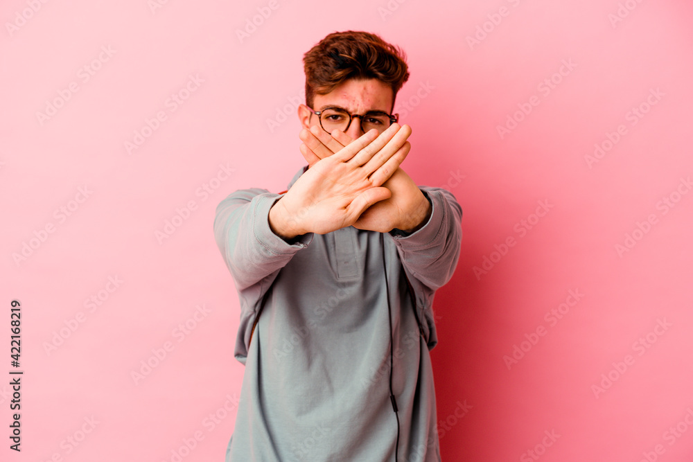 Young student man isolated on pink background doing a denial gesture Young student man isolated on pink background doing a denial gesture