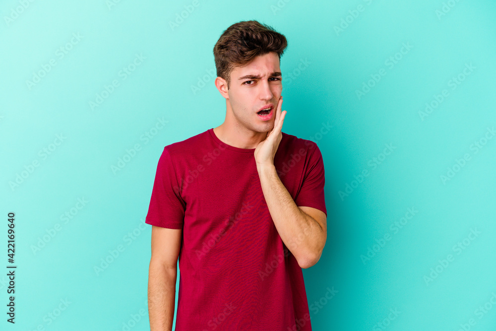 Young caucasian man isolated on blue background having a strong teeth pain, molar ache. Young caucasian man isolated on blue background having a strong teeth pain, molar ache.