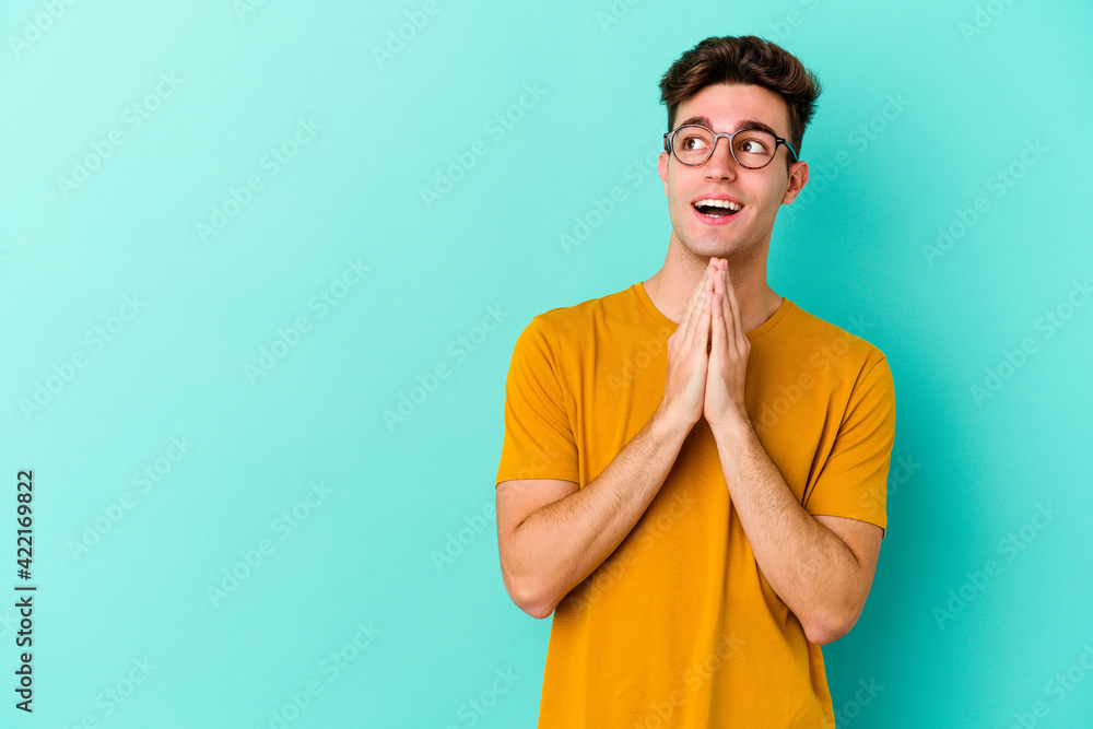 Young caucasian man isolated on blue background making up plan in mind, setting up an idea. Young caucasian man isolated on blue background making up plan in mind, setting up an idea.