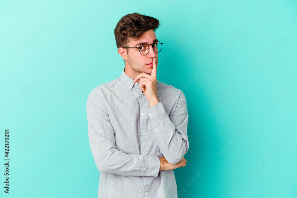 Young caucasian man isolated on blue background unhappy looking in camera with sarcastic expression. Young caucasian man isolated on blue background unhappy looking in camera with sarcastic expression.