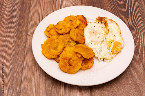 Plato de tostones con huevos fritos. Platillo de comida típica cubana y caribeña. photo
