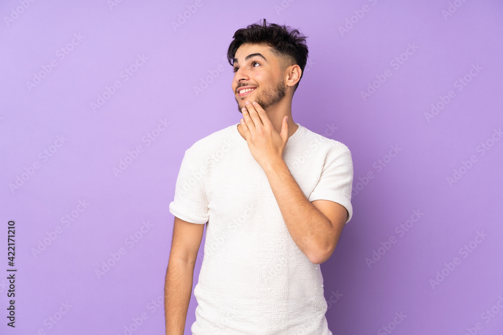 Arabian handsome man over isolated background looking up while smiling Arabian handsome man over isolated background looking up while smiling