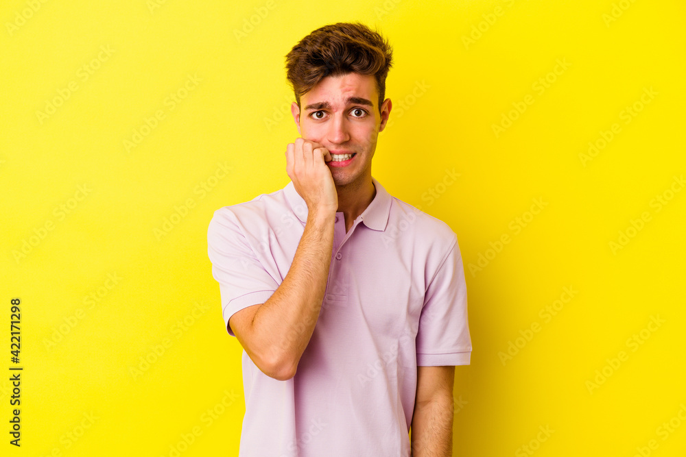 Young caucasian man isolated on yellow background biting fingernails, nervous and very anxious. Young caucasian man isolated on yellow background biting fingernails, nervous and very anxious.