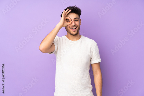 Arabian handsome man over isolated background showing ok sign with fingers