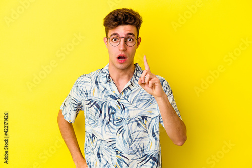 Young caucasian man isolated on yellow background having an idea, inspiration concept.