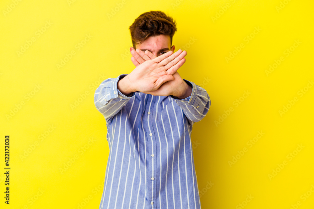 Young caucasian man isolated on yellow background doing a denial gesture Young caucasian man isolated on yellow background doing a denial gesture