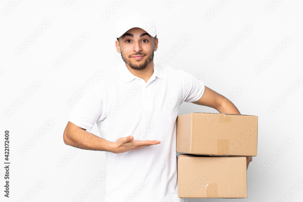 Delivery Arabian man isolated on blue background extending hands to the side for inviting to come Delivery Arabian man isolated on blue background extending hands to the side for inviting to come