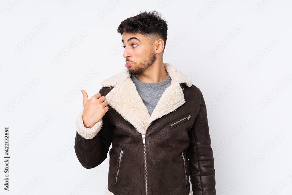 Arabian handsome man over isolated background unhappy and pointing to the side Arabian handsome man over isolated background unhappy and pointing to the side